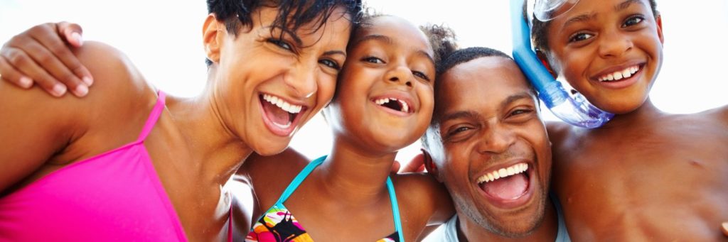 man and woman with two children in beach attire